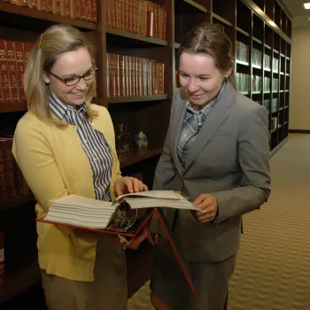 A central bookcase saves space by providing one set of volumes for judges and staff. Here, law clerks Mallory Montgomery and Zina Lapidus review a book.
